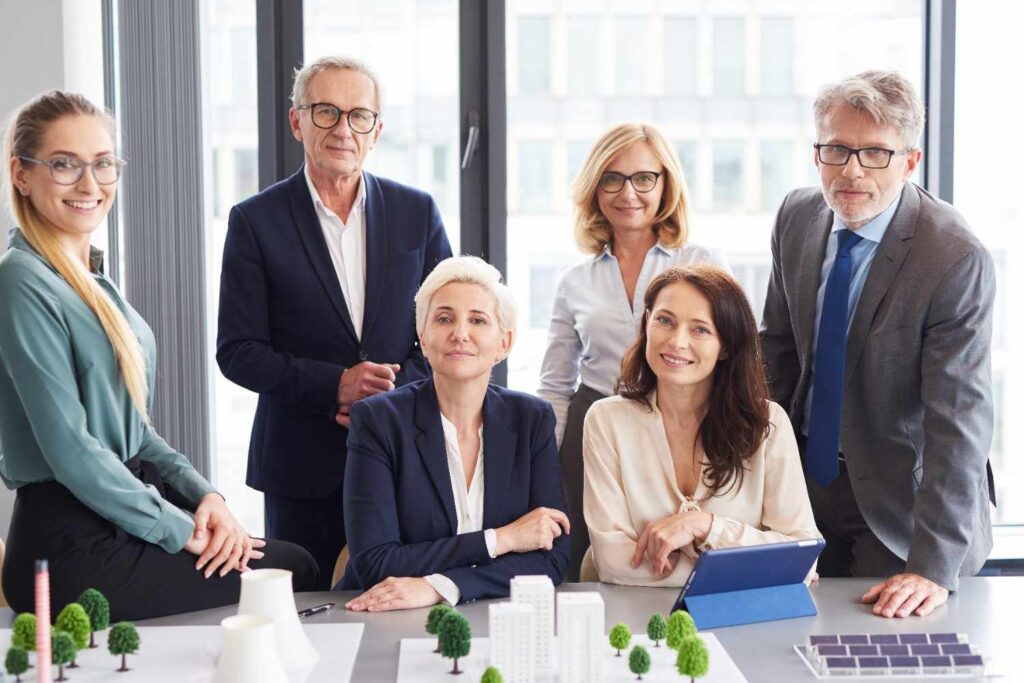Professional team gathered around table with architectural model